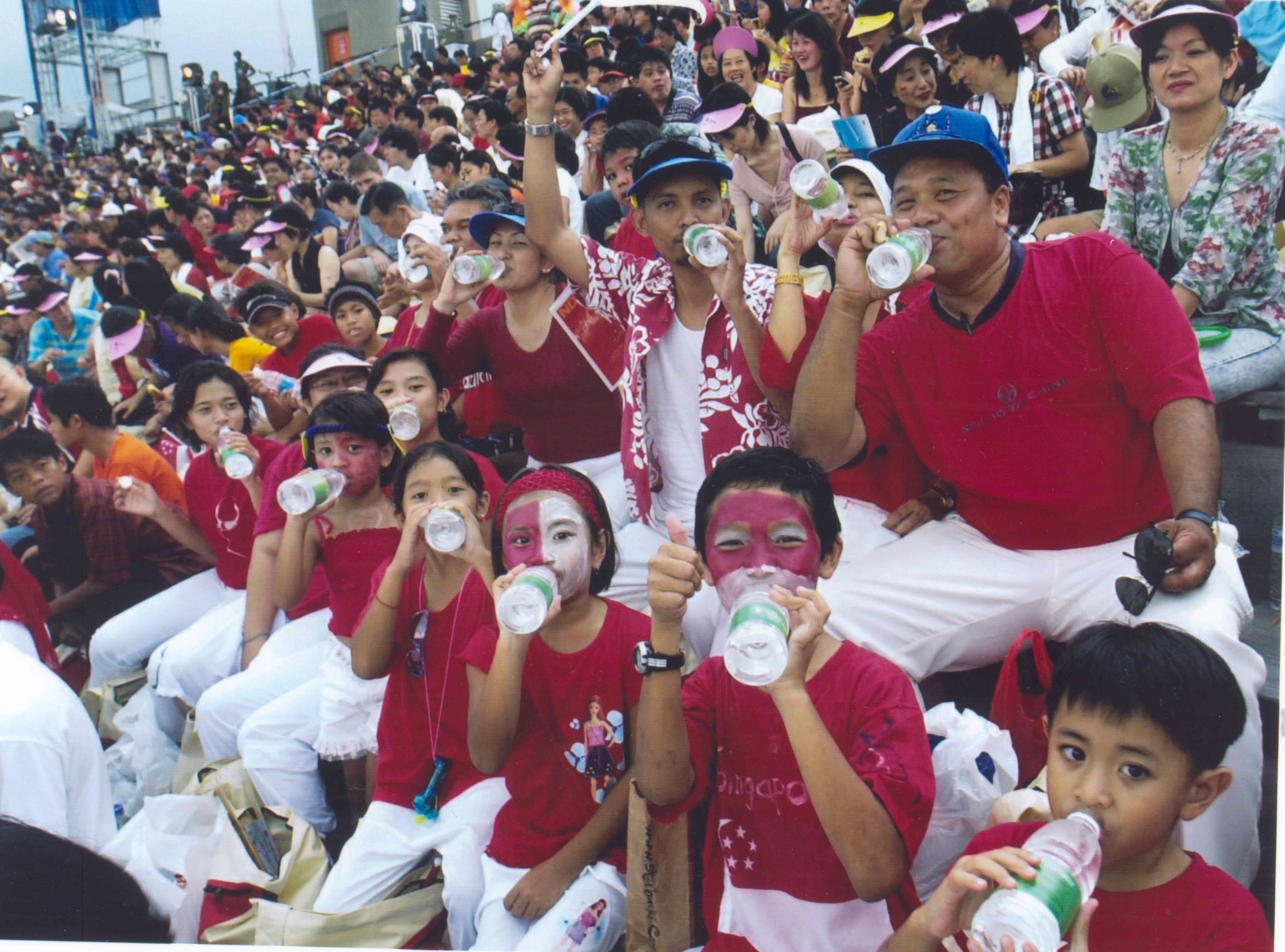Photo of Singaporeans drinking NEWater at the 2002 National Day Parade